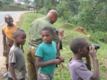 Boys waiting their turn for first look through binoculars, road to Lake Bunyonyi